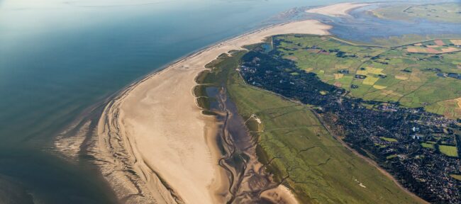 Header_Projektgebie_M_Stock Luftbild mit Blick über die natürliche Salzwiesen- und Dünenlandschaft und den Strand von St. Peter-Ording